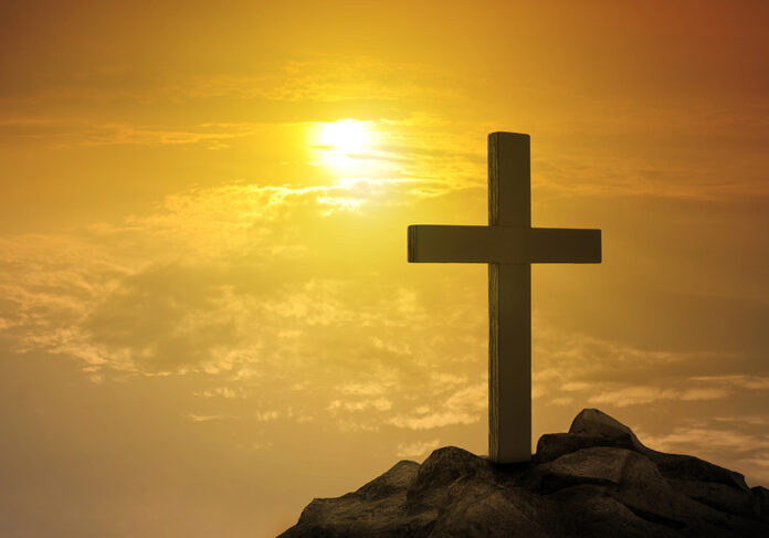Cross on hill at sunset